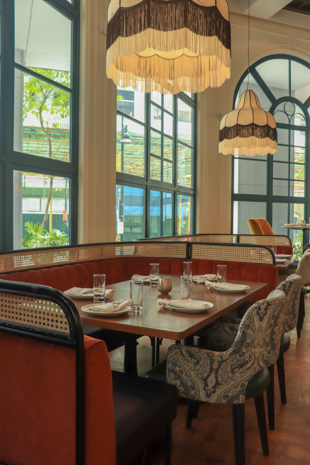 Rust-coloured banquette seating and patterned dining chairs around a restaurant table.
